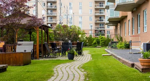 Garden courtyard with a gazebo, lawn and curved pathway.