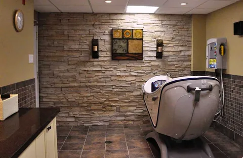 Accessible bathing room with an assisted bathtub and stone-pattern walls