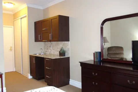 Bedroom corner with a kitchenette, dresser and large mirror