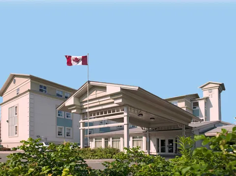 Residence building with a covered entrance, Canadian flag and shrubs