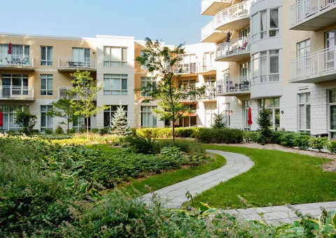 Residence buildings with balconies around a landscaped garden path