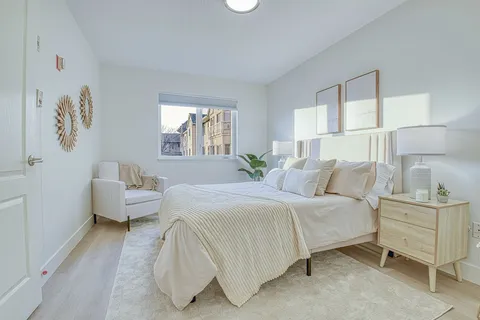 Studio bedroom with a double bed, armchairs and a bedside cabinet.