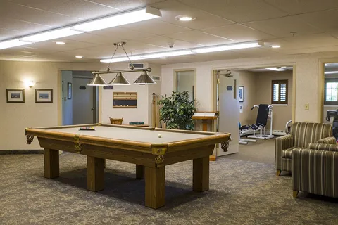 Games room with a billiards table and upholstered seating.