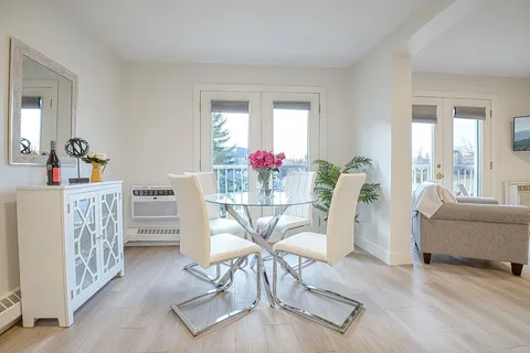 Suite dining area with a glass table, chairs and seating beyond.
