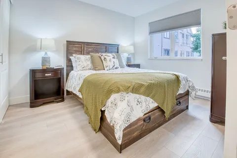 Bedroom with a double bed, dresser and bedside table.