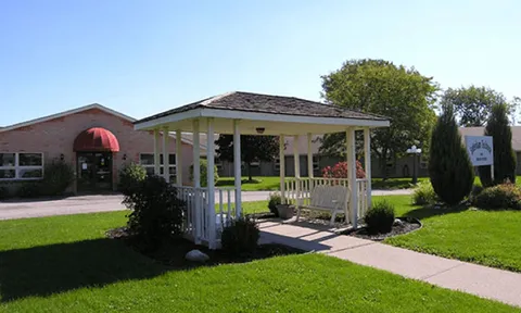 Garden gazebo beside a paved path and lawn.