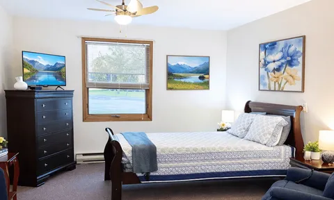Bedroom with a bed, dresser and window.