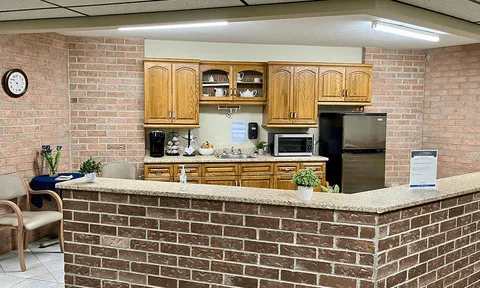 Kitchenette counter with wood cabinets and appliances.
