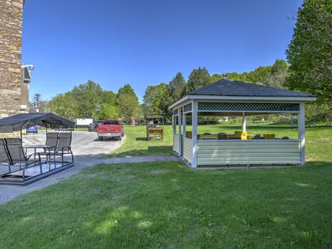 Garden gazebo and covered swing on a lawn beside the residence.
