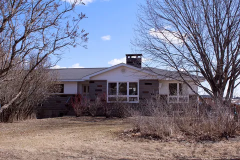 Single-storey residence behind leafless trees.