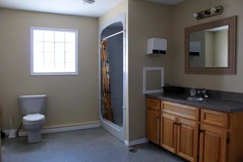Accessible bathroom with shower, toilet and vanity.