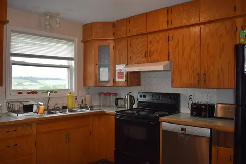 Shared kitchen with wooden cabinets and cooking appliances.