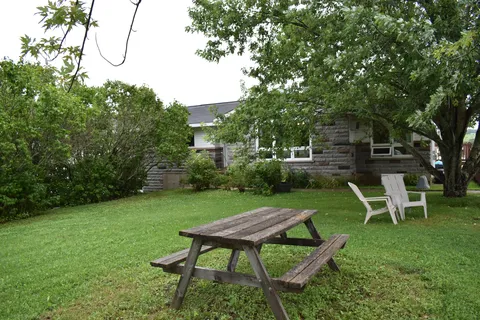 Garden lawn with a picnic table and outdoor chairs.