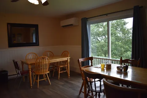 Dining area with wooden tables and a large window.