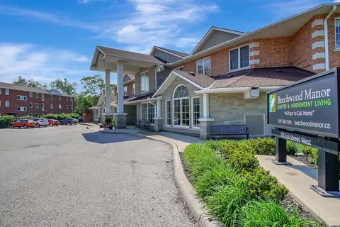 Covered entrance with glazed doors, paving and the residence sign.