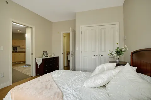 Bedroom with a double bed, bedside table and an open doorway.