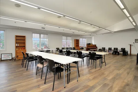 Dining room with tables, chairs and large windows.