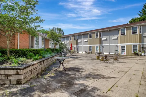 Courtyard patio with benches, raised garden beds and outdoor tables.