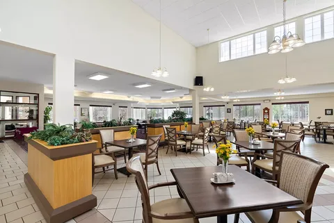 Dining area with tables, chairs, pendant lights and flower vases