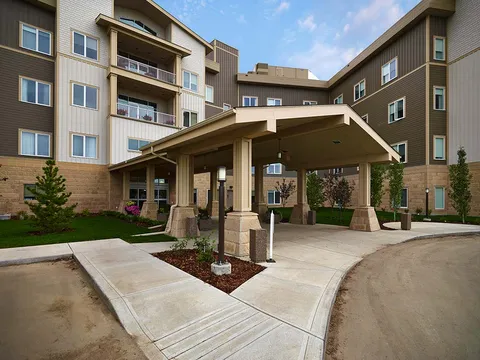 Covered entrance with glass doors and a landscaped approach