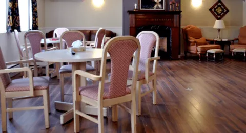 Lounge with round table, chairs and fireplace
