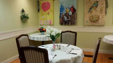 Dining table with upholstered chairs and framed artwork