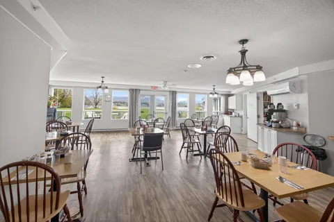 Dining room with large windows and wooden tables set with cups