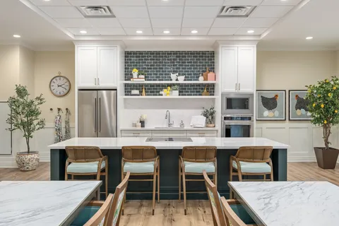 Craft kitchen with an island, stools, appliances and tables.