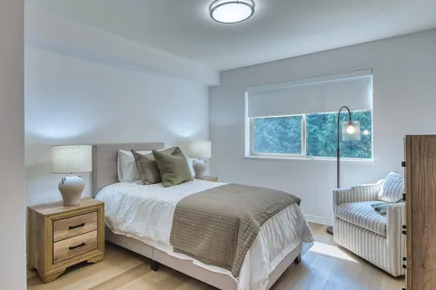Bedroom with a bed, bedside tables and a large window