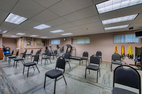Exercise room with chairs, fitness equipment and resistance bands