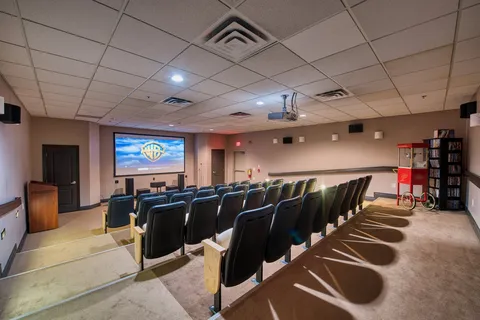 Cinema room with rows of seats and a projection screen