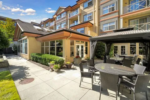 Residence exterior and patio seating beside the covered entrance