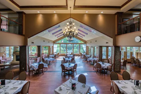 Dining room with set tables beneath a vaulted ceiling