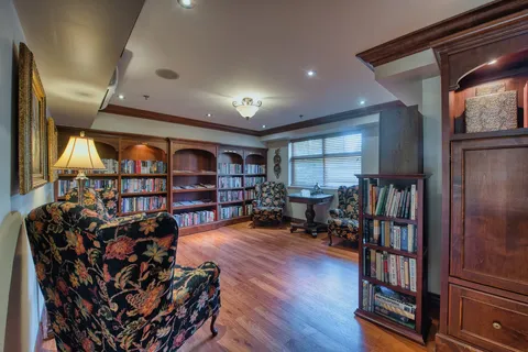 Library with bookshelves, armchairs and a reading table
