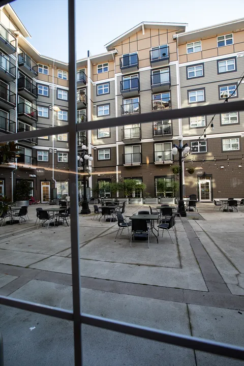 Courtyard with patio tables surrounded by multi-storey buildings
