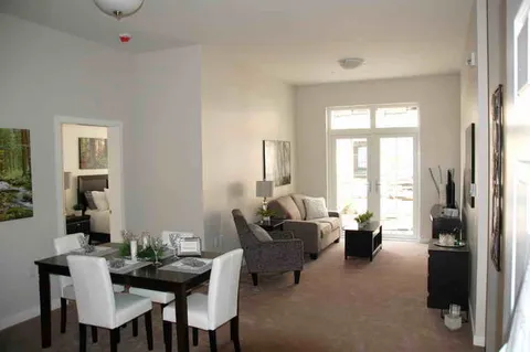 Open suite with dining table, sofa, television and patio door