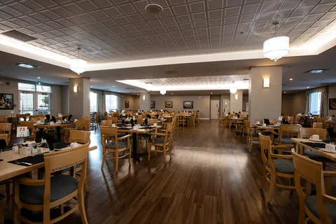 Dining room with wooden tables, chairs and pendant lights