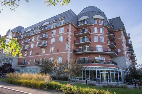 Brick residence with balconies, a glazed garden room and planted beds