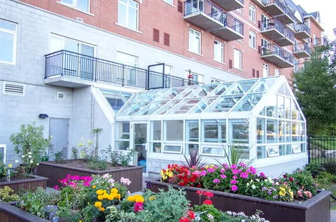 Raised flower beds beside a glass garden room