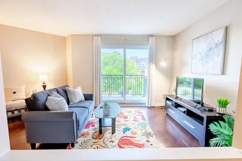 Sitting area with a sofa, television and coffee table beside glass doors