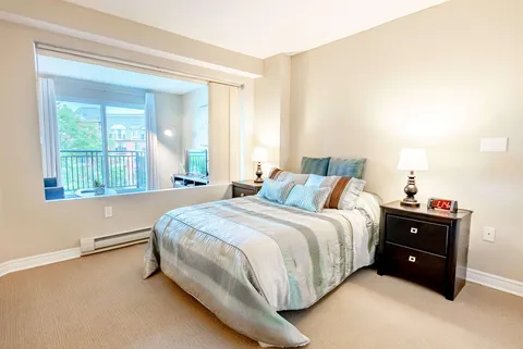 Bedroom with striped bedding, bedside drawers and a window