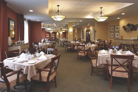 Dining room with wooden chairs, set tables and pendant lights