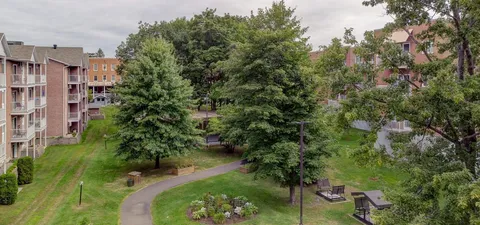 Garden paths and benches among lawns, trees and residence buildings