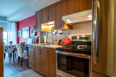 Apartment kitchen with wooden cabinets and appliances.