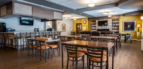 Dining room with wooden tables, chairs and a service counter.