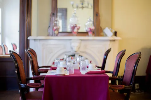 Set dining tables with upholstered chairs and a large wall mirror