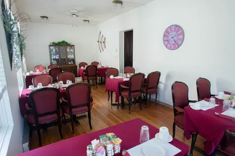 Dining room with set tables, chairs, mirrors and hanging lights