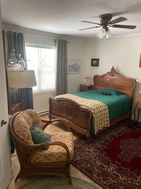 Bedroom with a wooden bed frame and armchair.