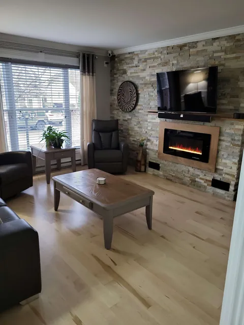Lounge with a television above a fireplace.