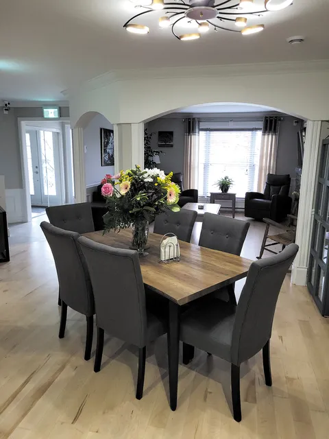Dining area with a wooden table and grey chairs.